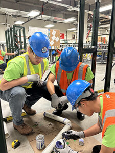 Jack Roessler trains two MTA interns wearing construction gear