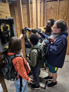 Students practice wiring a doorbell under the supervision of journeyworkers from Local 110.